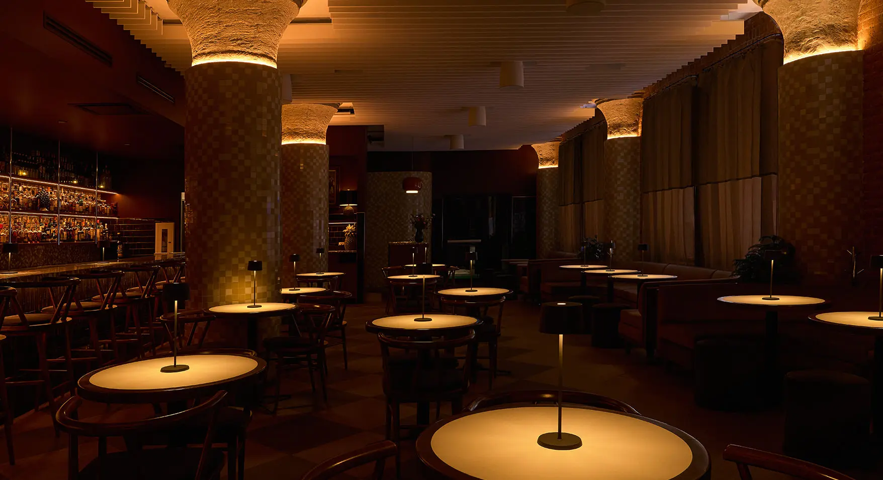 Chic cocktail bar in downtown Montreal showcasing elegant seating and warm ambiance at Bar Le Mal Nécessaire
